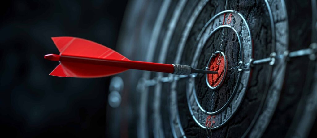 Ein roter Dartpfeil, der präzise das Bullseye einer schwarzen Dartscheibe trifft. Dies Bild symbolisiert die Marketingziele